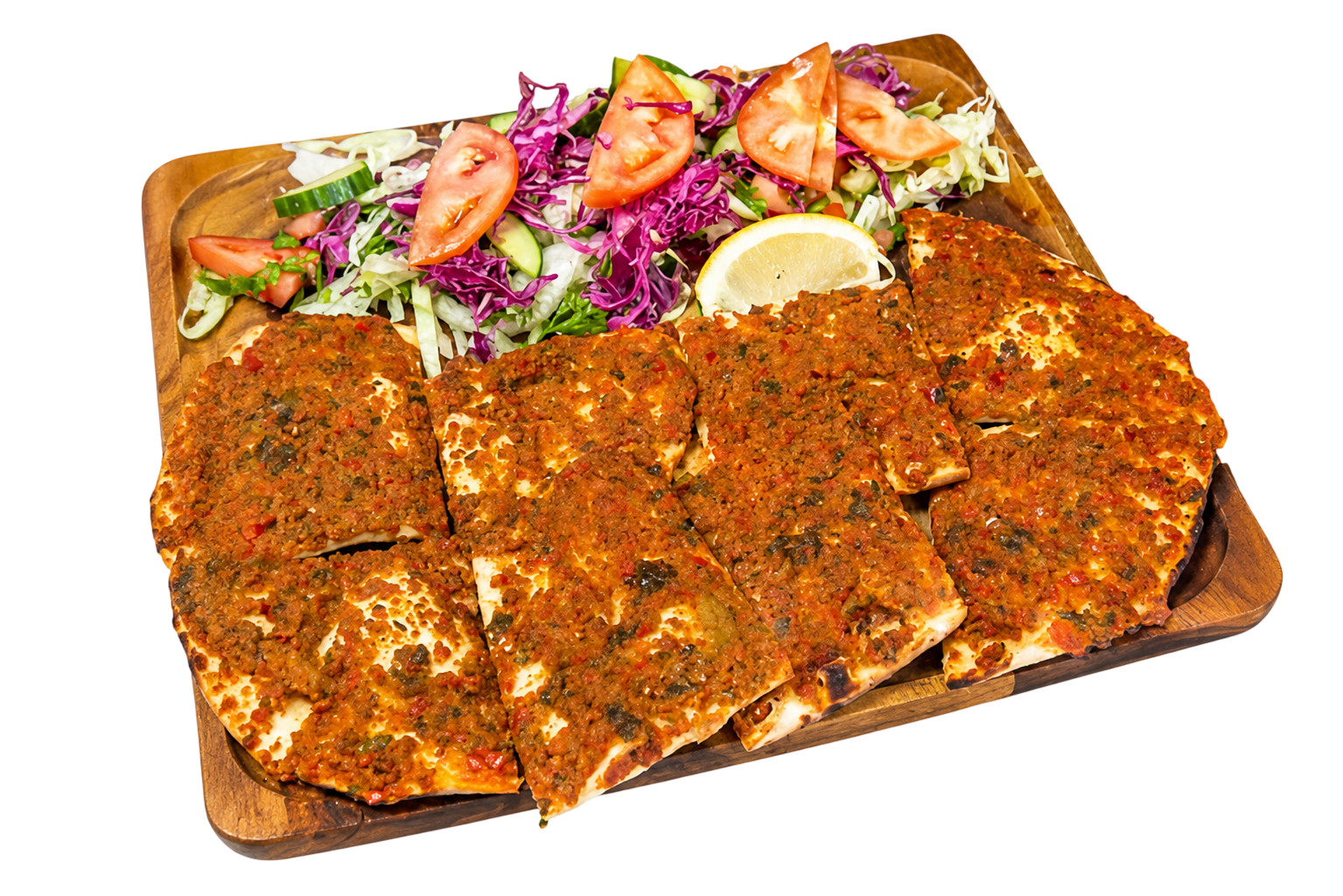 Wooden platter with Turkish lahmacun topped with minced meat and herbs, served with salad and lemon wedge.