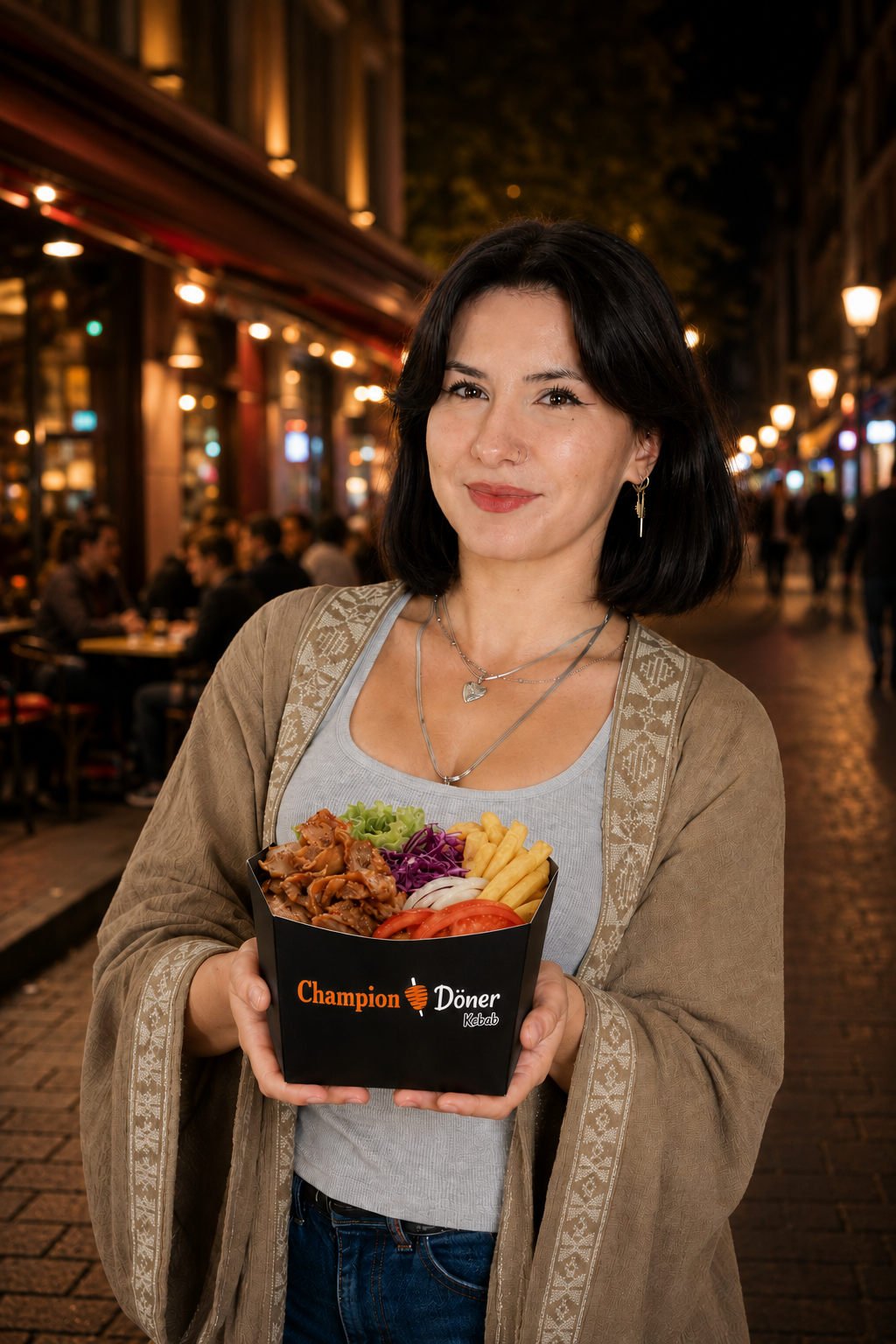 Woman holding a box of Champion Döner Kebab with fries, meat, and vegetables at night street.